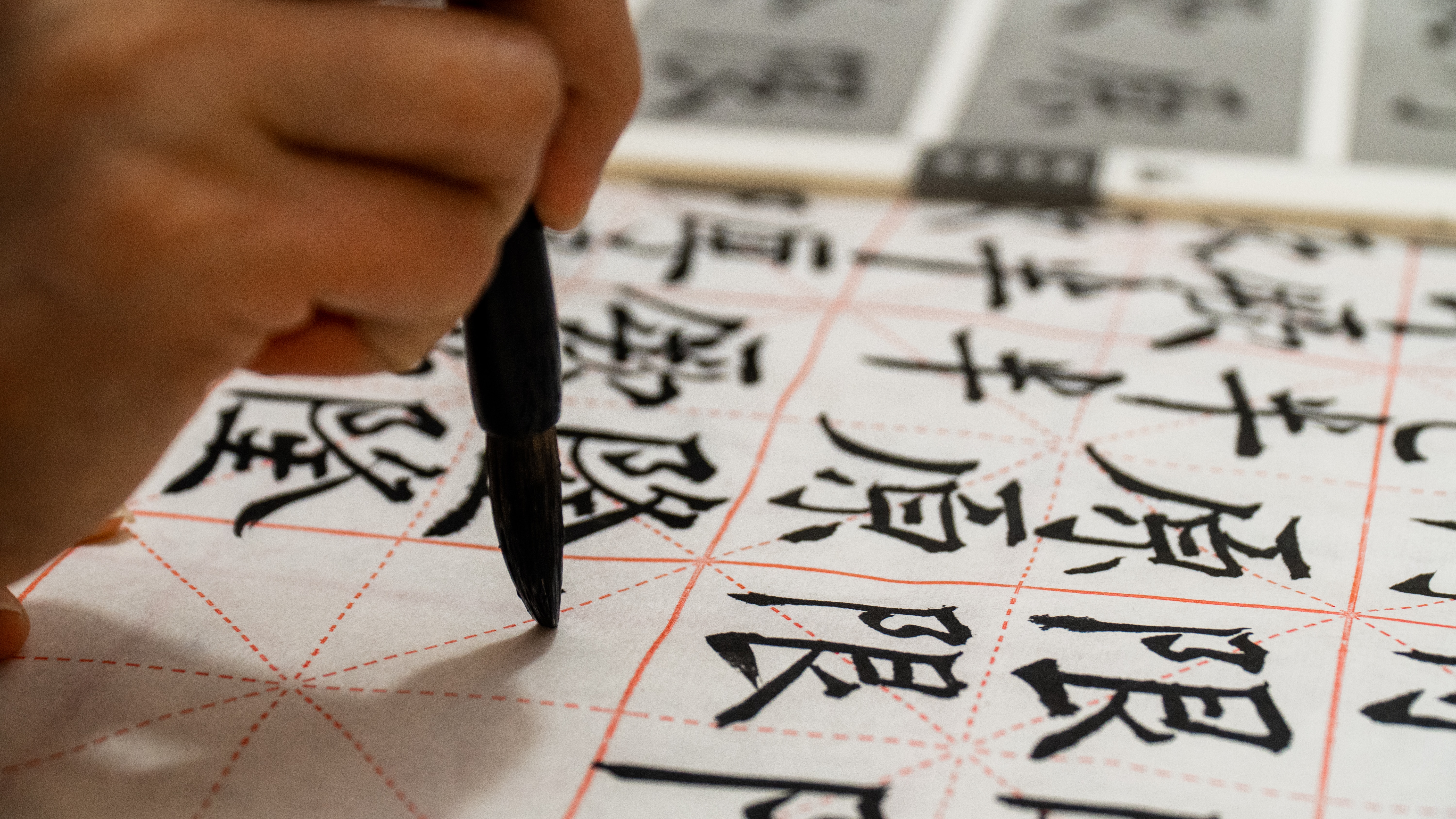 person writing Chinese calligraphy
